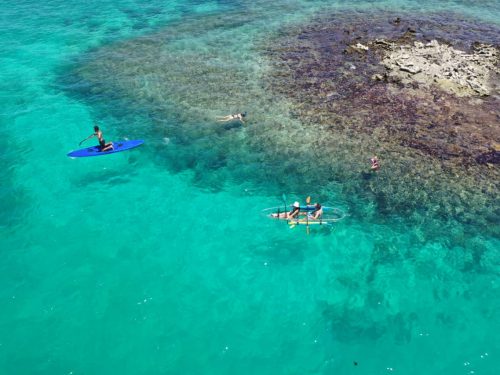Persona practicando kayak en aguas turquesas del Caribe.